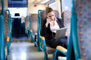 Businesswoman listening to music and using tablet computer on th