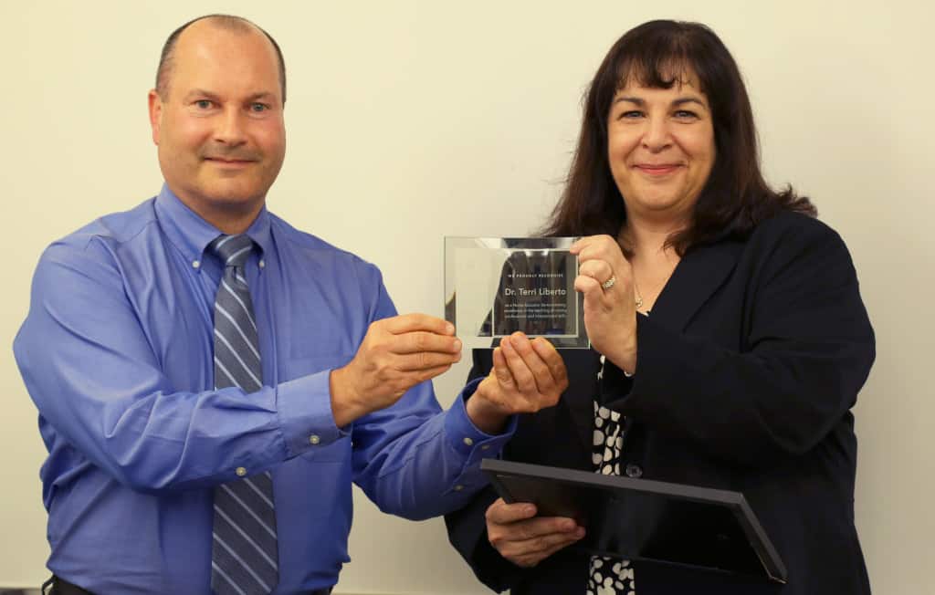 John Goodman, client executive for Assessment Technologies Institute, presents The Educator with the Nurse’s Touch Award to Terri Liberto, associate professor and chair of nursing at La Roche College, on Oct. 14. Photo Credit: Becky Jeskey
