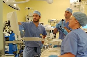 Dr. Matthew Synan is using the thoracic navigation machine and a tip-tracked instrument in his bronchoscope and is able to see exactly where he is in the patient’s lungs, as well as where he needs to go in order to reach the target. Notice the square field generator over the patient that can track patient breathing in order to compensate for respiratory motion.