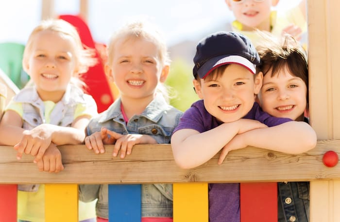 summer, childhood, leisure, friendship and people concept - group of happy kids on children playground