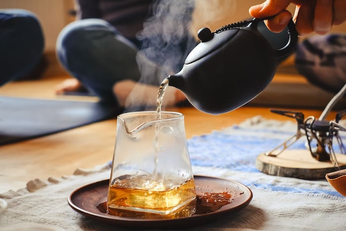 Master making chinese tea in traditional ceremony and pouring tea from teapot with vapor
