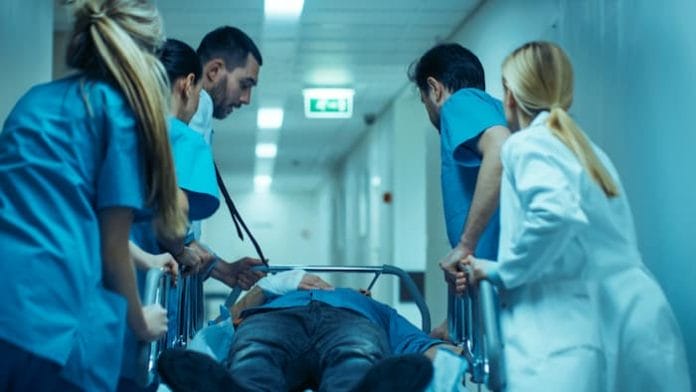 Emergency Department: Doctors, Nurses and Surgeons Move Seriously Injured Patient Lying on a Stretcher Through Hospital Corridors. Medical Staff in a Hurry Move Patient into Operating Theater.