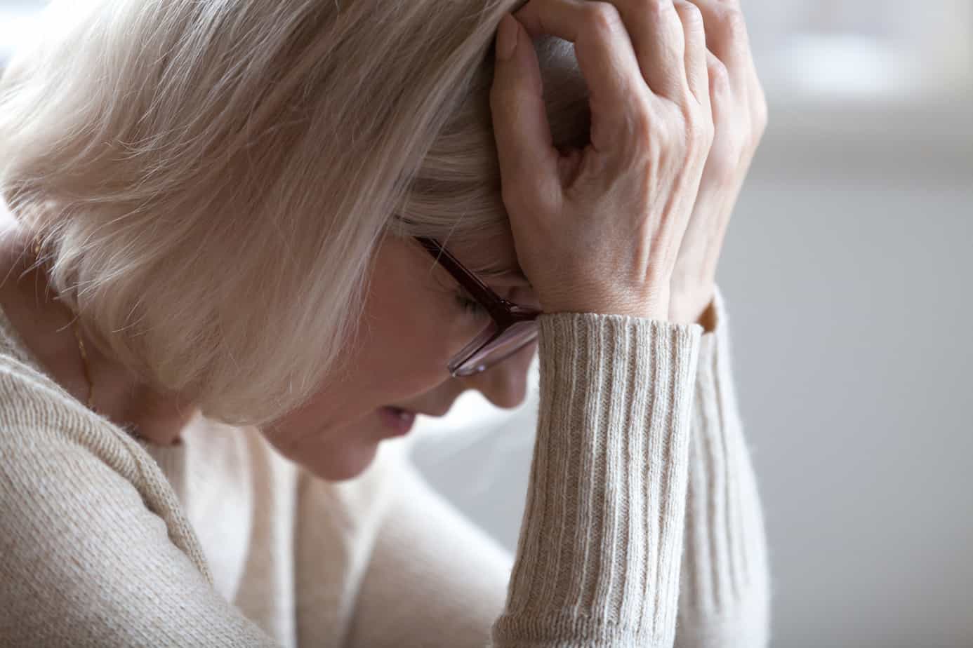 Stressed sad tired middle aged senior woman holding head in hands feeling headache migraine concept, upset old elderly mature lady in panic suffering from pain, alzheimer disease, anxiety depression
