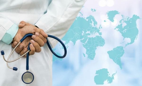 a doctor in a white coat with a stethoscope standing in front of a world map a doctor standing in front of a world map