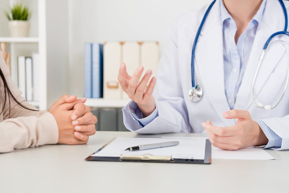 closeup of female doctor explain disease treatment solution for patient in clinic. selective focus photo.