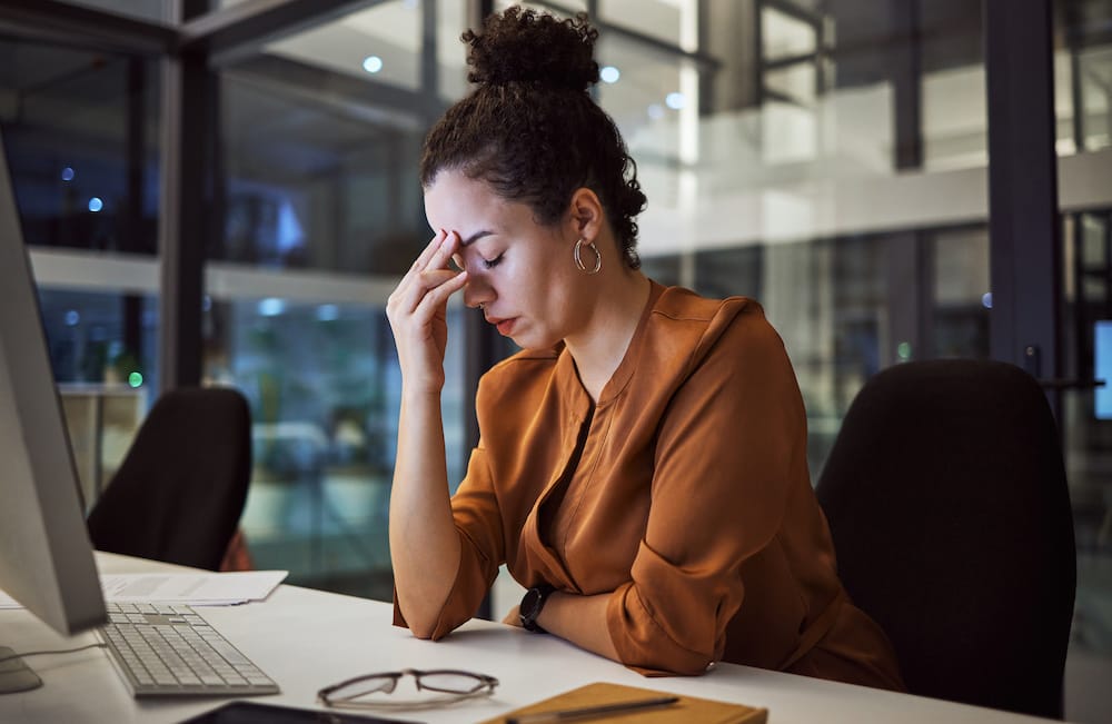 Woman working at night with headache, burnout and stress over social media marketing project or company deadline. Anxiety, exhausted and tired web or online business advertising expert with migraine.