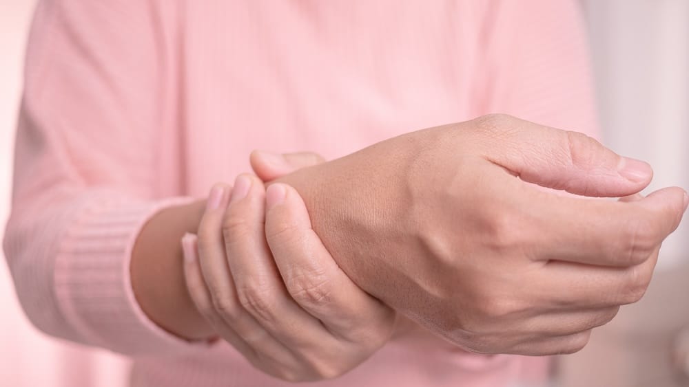 Closeup of female holding her painful wrist caused by prolonged work on the computer or housewife, Carpal tunnel syndrome, arthritis. Neurological disease concept.