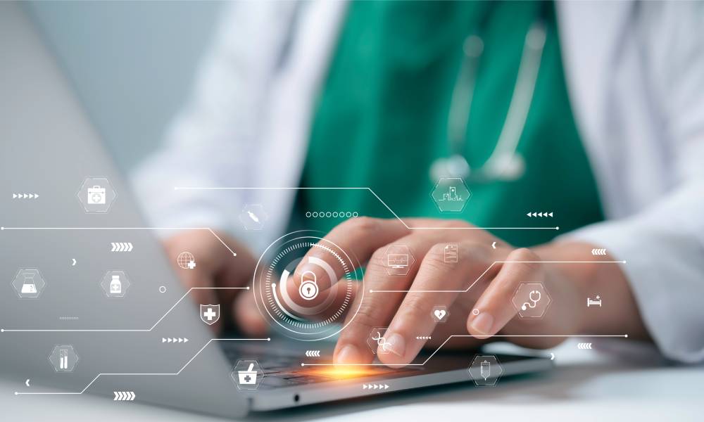 A person in a white lab coat sits at a laptop with their hands at the keyboard and abstract security symbols in the foreground.