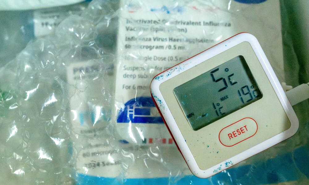 Pharmaceuticals in a Styrofoam container with bubble wrap and ice packs. A thermometer reading 5 degrees Celsius is on top.